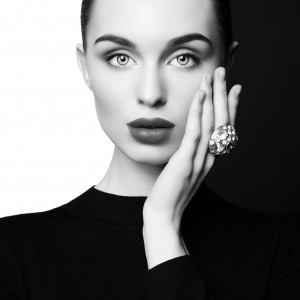 young sexy lady with big ring with diamonds in black-and-white studio. beautiful woman with perfect lips and black lipstick poses in photostudio. Fashion portrait of fashionable model.