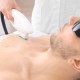 Handsome man getting laser epilation in beauty salon